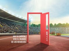 an open red door in front of a large stadium filled with people and spectators on a sunny day