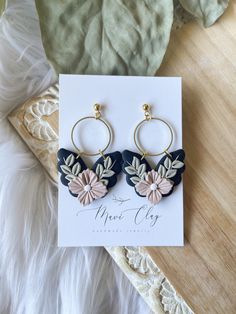 a pair of earrings sitting on top of a card