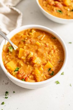 two bowls filled with soup on top of a table