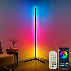 a remote control sitting next to a colorful light in a room with a phone on the floor