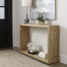 a living room with a table and vases on the floor next to a painting