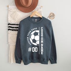 a hat and sweater hanging on a rack next to a wall with a soccer ball