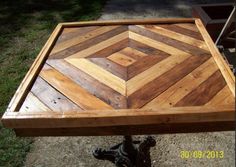 a wooden table sitting on top of a grass covered field