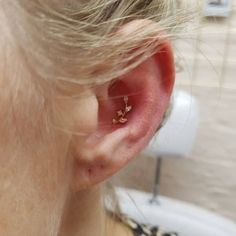 a close up of a person's ear with a small piece of jewelry on it