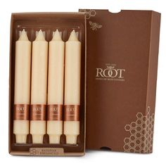 four beeswax candles in a cardboard box with the packaging on it's side