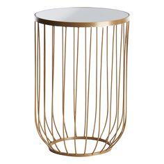 the side table is made from brass wire and has a round glass top with gold metal bars