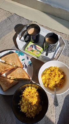 there are two plates with food on them next to some cups and spoons in front of the plate