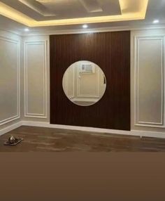 an empty room with a round mirror on the wall