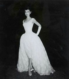 a black and white photo of a woman in a dress with her hands on her hips