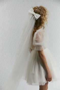 The bridal veil is made of soft tulle. It is embellished with a dotted bow. The perfect wedding look with our short wedding Janet dress.

Color: off-white.

#weddingveil #weddingdress #tulleveil #modernveil #veilwithbow Modern Veil, Second Wedding Dresses, Tulle Mini Dress, Mini Wedding Dresses, Tulle Veils, Princess Skirt, Long Veil, Wedding Hat, Mini Wedding