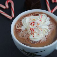 a cup of hot chocolate with whipped cream and candy canes