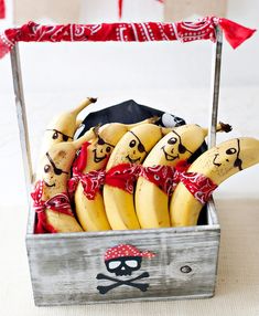 some bananas are in a box with pirate decorations on them and tied to the side