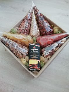 a box filled with assorted meats and beans on top of a wooden table