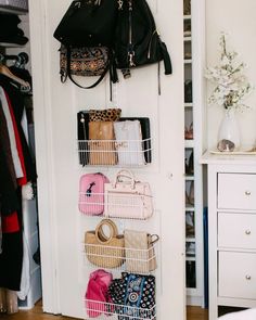 a closet with several baskets and purses hanging on the wall next to a bed