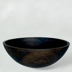 a wooden bowl sitting on top of a white table