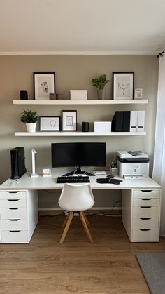 a white desk topped with a computer monitor next to a keyboard and mouse on top of a hard wood floor