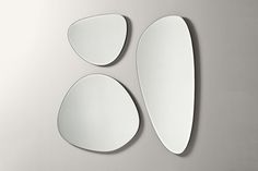 three oval mirrors sitting on top of a wall