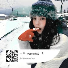 a woman in winter clothing eating food on the snow covered ground