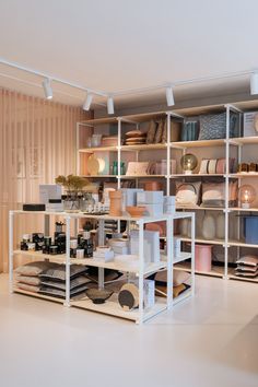 a room filled with lots of different types of plates and vases on shelving