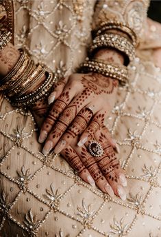 the bride's hands are decorated with hennap and bracelets for her wedding day