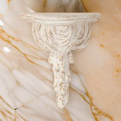 a white marble shelf with an ornate design on it's face and bottom part