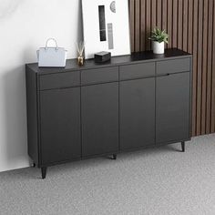 a black sideboard sitting next to a white bag on top of a wooden cabinet