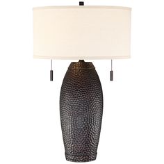 a table lamp with a white shade on it and a black vase in the middle