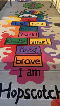 the sidewalk has been painted with different colors and words, including words that spell i am hopscotch