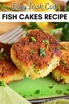 two fish cakes on a green plate with lemons and parsley in the background