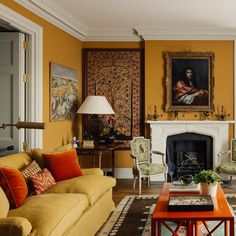 a living room filled with furniture and a fire place under a painting on the wall