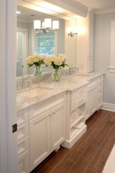 a large bathroom with two sinks and mirrors