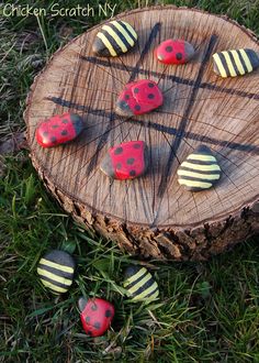 four red and white buttons sitting on top of a piece of wood in the grass