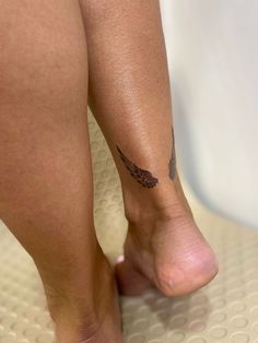 a close up of a person's foot with a tattoo on her left leg