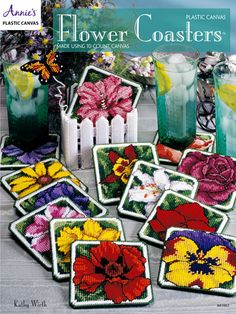 cross stitch book with flower coasters on the cover and flowers in vases next to it