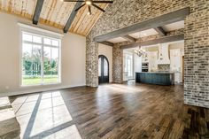 an empty living room with wood floors and exposed ceilings