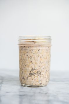 a jar filled with oatmeal sitting on top of a marble countertop