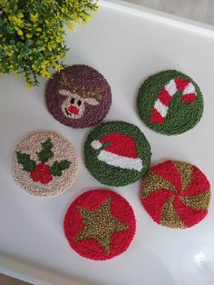 four knitted coasters with christmas decorations on them