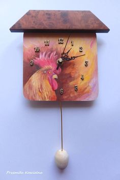 a clock with a painting of a rooster on it's face hanging from a wall