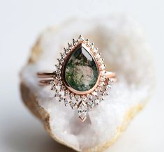 a close up of a ring on top of a piece of rock with diamonds around it