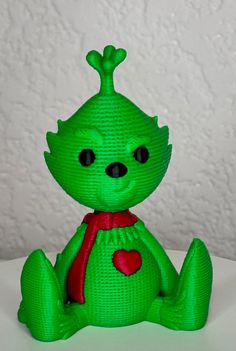 a green toy sitting on top of a white table