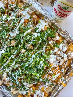 a casserole dish with chicken, lettuce and ranch dressing on top