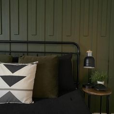 a bedroom with green walls and black bedding