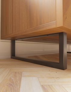 a wooden cabinet sitting on top of a hard wood floor