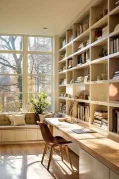 a home office with lots of bookshelves and a desk in front of a large window