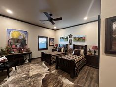 a bedroom with two beds and paintings on the wall