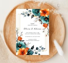 an elegant wedding card with orange and blue flowers