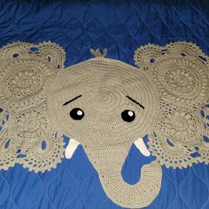 an elephant made out of crocheted doily on a blue quilted bed