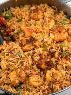 a pan filled with rice and shrimp on top of a stove