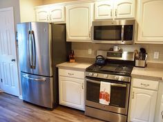 a kitchen with stainless steel appliances and white cabinets