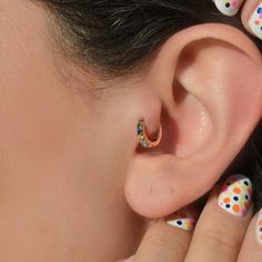 a close up of a person's ear with polka dot designs on it and a piercing in the middle